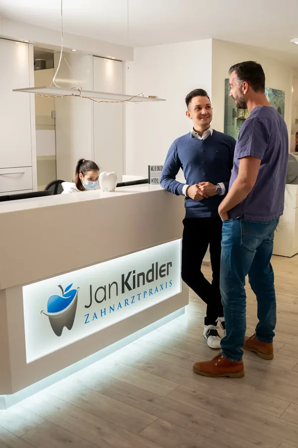 Empfang der Zahnarztpraxis Kindler mit Praxislogo an der Wand